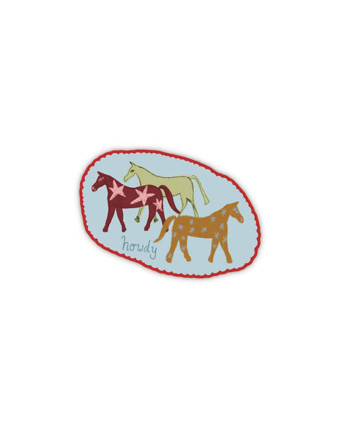 rustic oval-shaped sticker with three illustrated horses and the message "howdy" in blue.