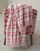 boucle throw blanket in a pink plaid pattern