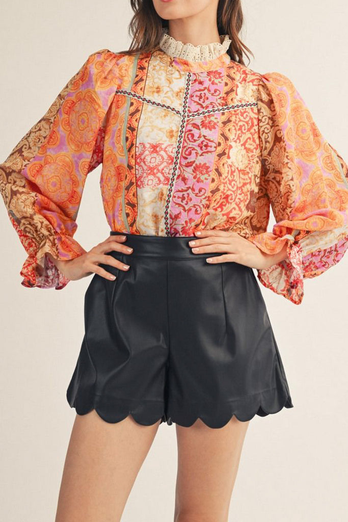 lightweight blouse with a colorful mixed print design in shades of orange, red, pink, and yellow