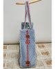 oversized quilted tote bag in faded denim blue with embroidered details in red and green