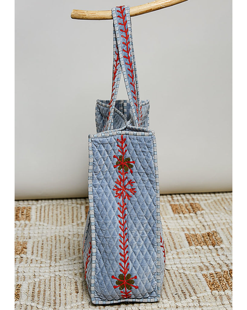 oversized quilted tote bag in faded denim blue with embroidered details in red and green