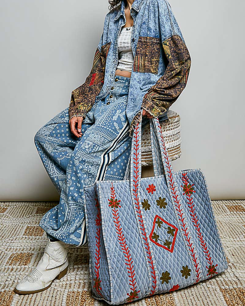oversized quilted tote bag in faded denim blue with embroidered details in red and green