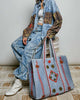 oversized quilted tote bag in faded denim blue with embroidered details in red and green