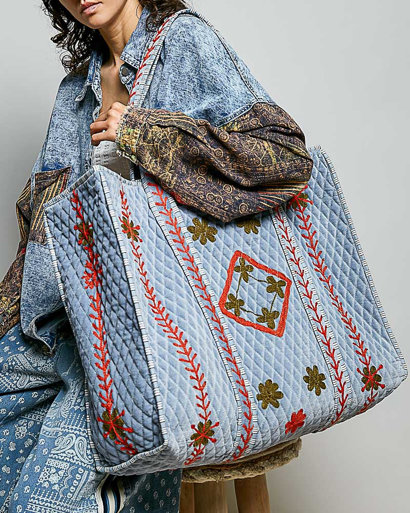 oversized quilted tote bag in faded denim blue with embroidered details in red and green