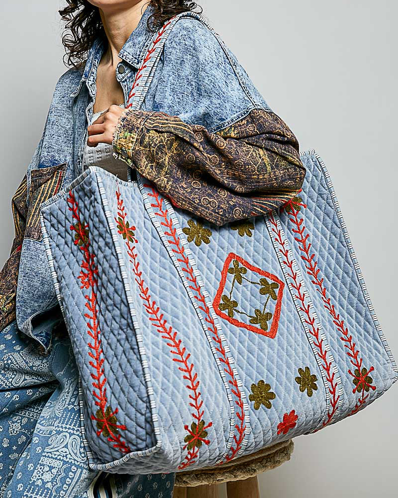 oversized quilted tote bag in faded denim blue with embroidered details in red and green
