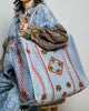 oversized quilted tote bag in faded denim blue with embroidered details in red and green