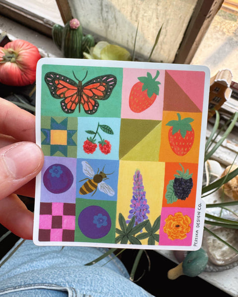 colorful sticker with a quilt-inspired design featuring berries and pollinators