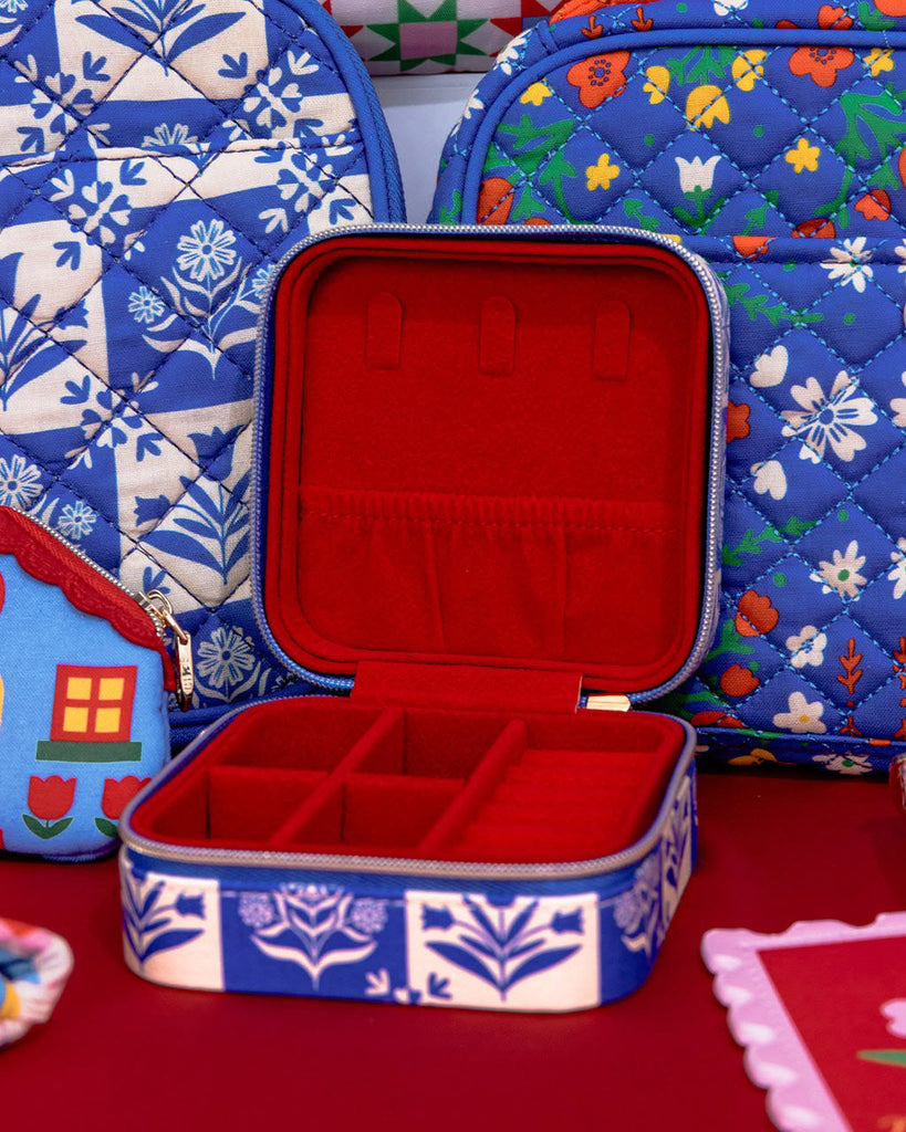 travel jewelry organizer in a blue plaid floral pattern and red faux suede lining