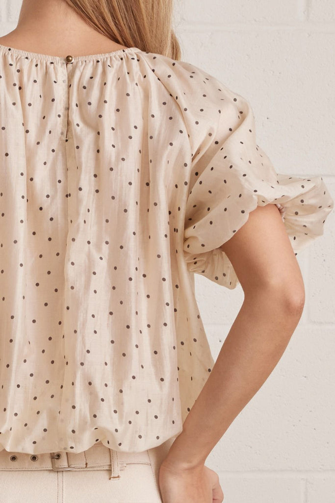 lightweight short sleeve top in shimmery ecru with petite black polka dots throughout.