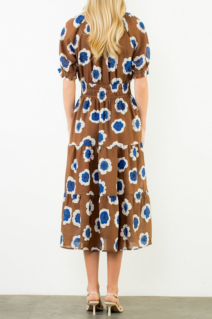 striking midi dress in a bold brown, blue, and white floral pattern