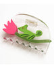 clear acetate hair claw with a green chameleon holding on to a pink tulip