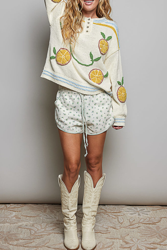 roomy chenille henley-style pullover with orange slice applique details on front.