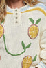 roomy chenille henley-style pullover with orange slice applique details on front.