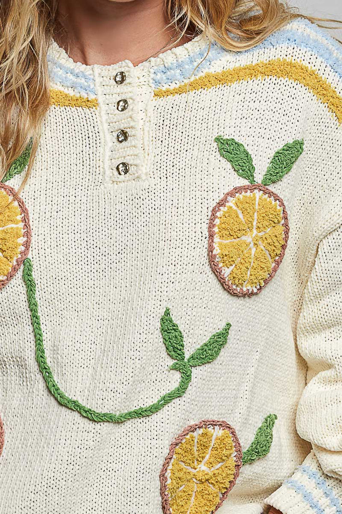 roomy chenille henley-style pullover with orange slice applique details on front.