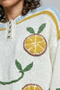 roomy chenille henley-style pullover with orange slice applique details on front.
