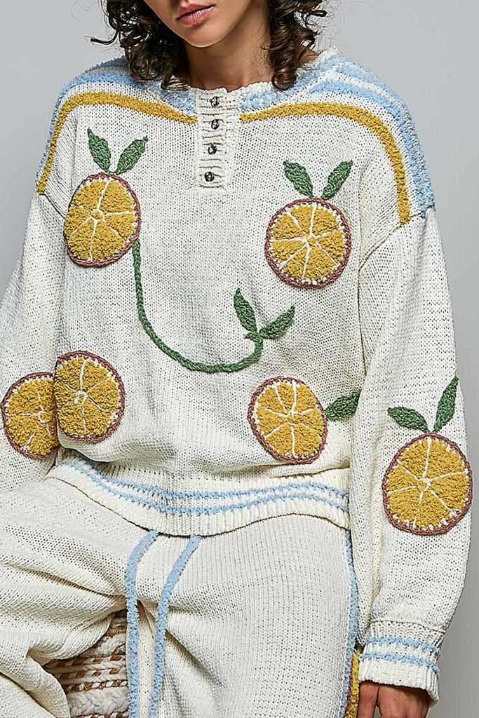 roomy chenille henley-style pullover with orange slice applique details on front.