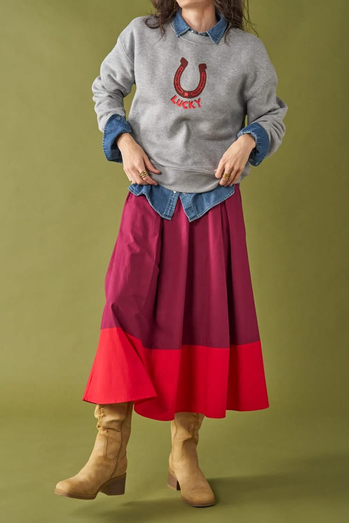 a-line midi skirt with a color blocked design in poppy red and burgundy