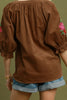 camel brown corduroy top with colorful embroidered floral details on sleeves.