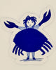 A die-cut sticker featuring a whimsical illustration of a girl with curly hair wearing a large blue crab shell dress, standing on a cream-colored background.
