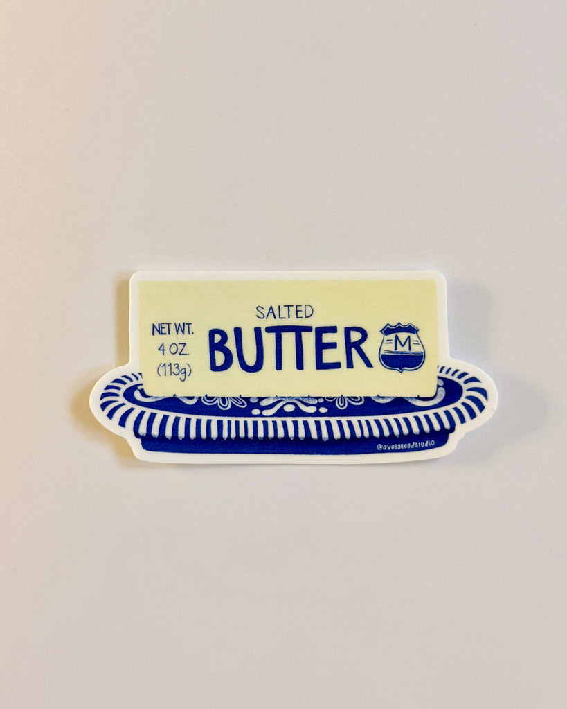 die-cut sticker in the shape of a stick of butter on a blue and white china dish