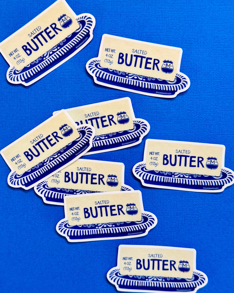 die-cut sticker in the shape of a stick of butter on a blue and white china dish