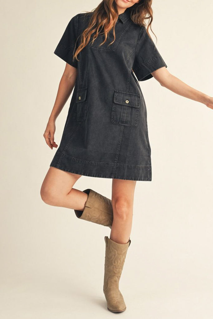 washed black denim mini dress with a collared v neckline and front patch pockets 