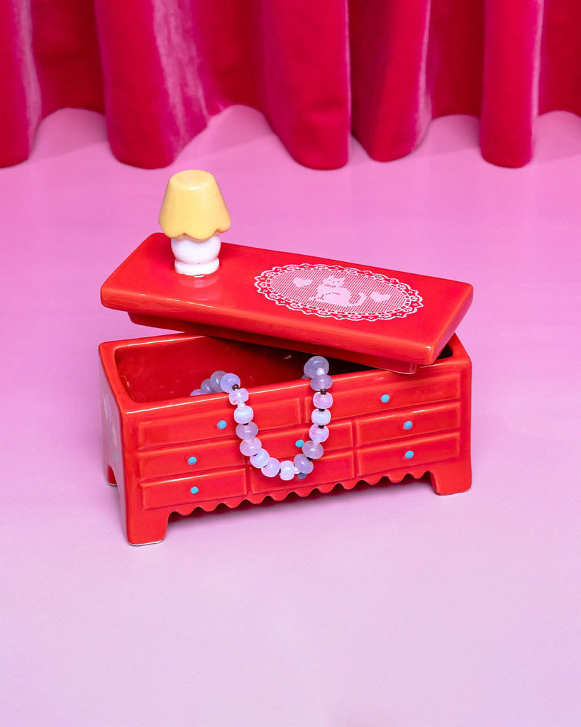 ceramic trinket box in the shape of a red dresser