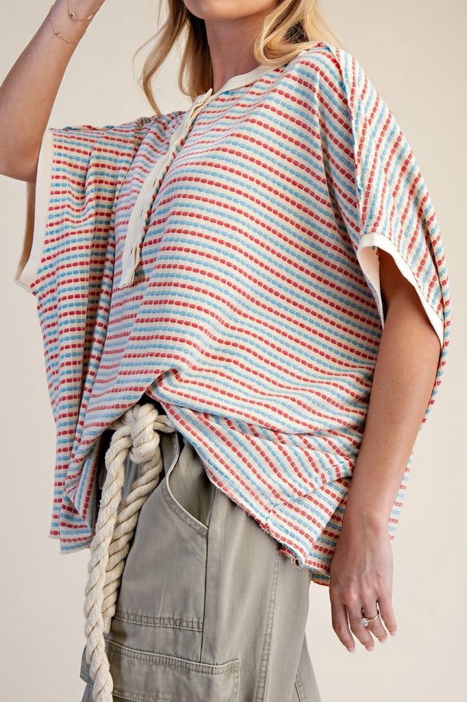 oversized cream colored top in turquoise and red stripes