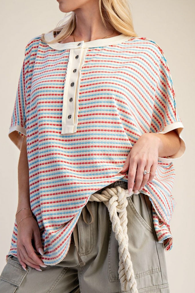 oversized cream colored top in turquoise and red stripes