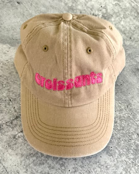 baseball cap with embroidered message croissants in hot pink