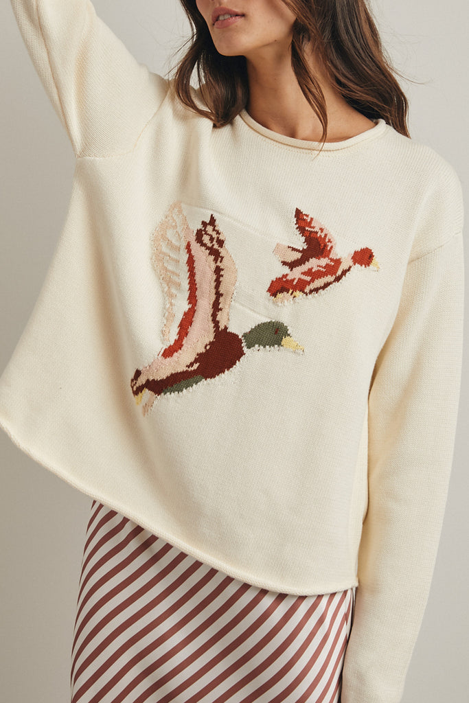 cream colored sweater with a cute knit flying duck knit graphic