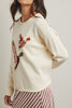 cream colored sweater with a cute knit flying duck knit graphic