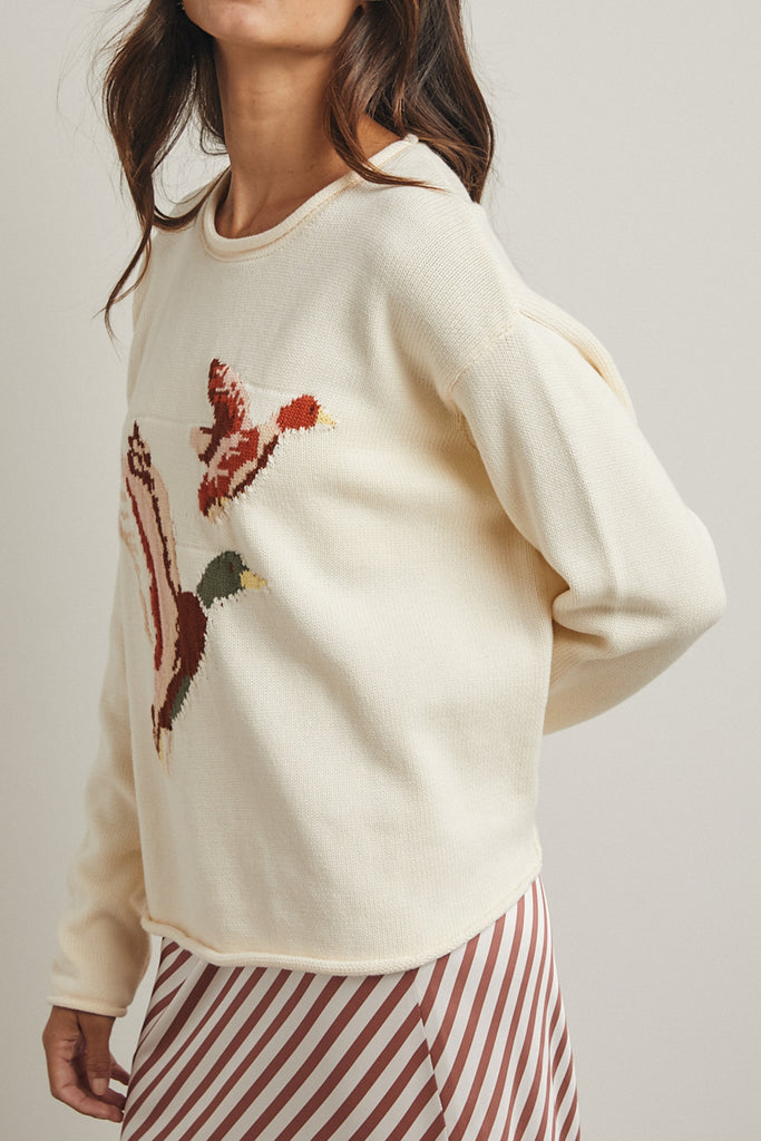 cream colored sweater with a cute knit flying duck knit graphic