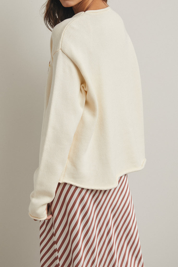 cream colored sweater with a cute knit flying duck knit graphic
