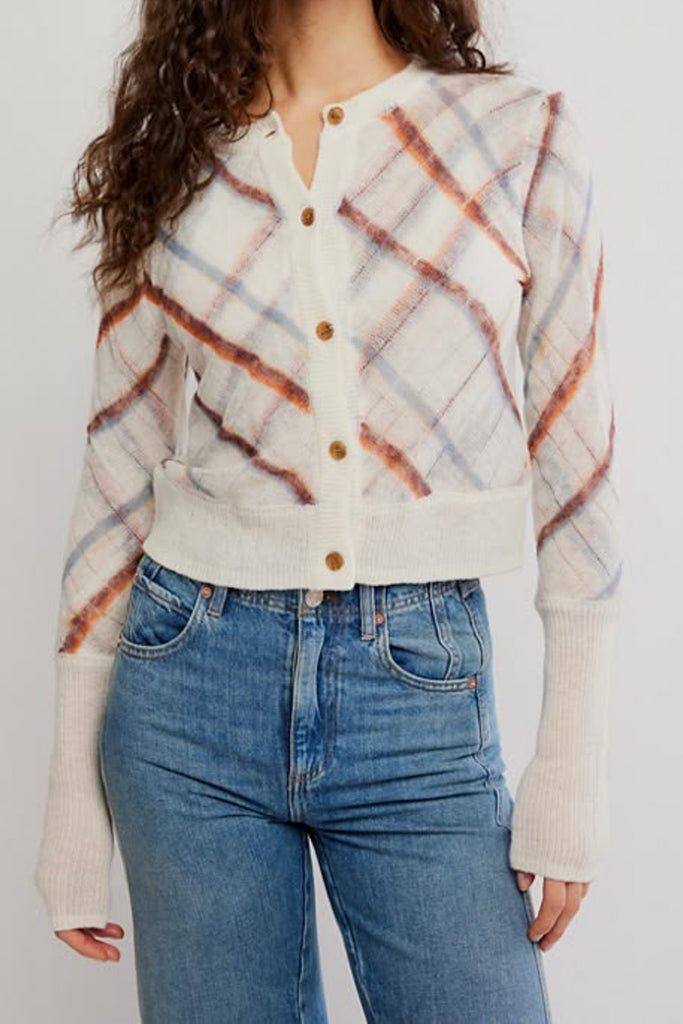 free people fitted white cardigan with a muted plaid design.