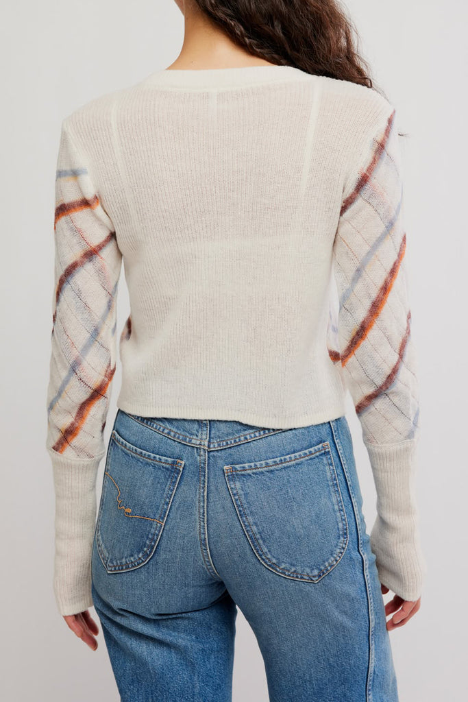 free people fitted white cardigan with a muted plaid design.