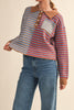 unique sweater in camel, grey, bright blue, and red stripes.