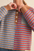 unique sweater in camel, grey, bright blue, and red stripes.