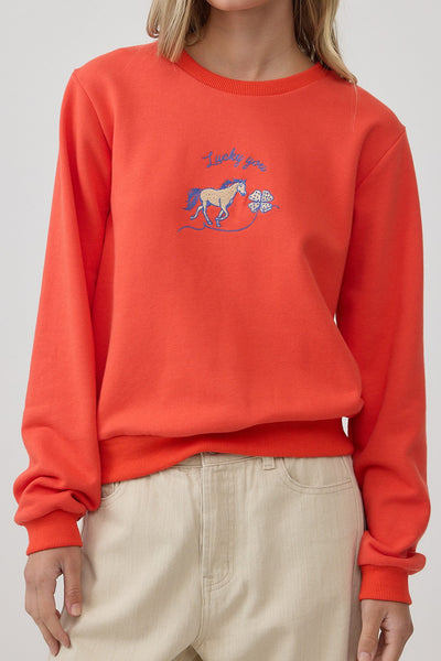 orange crew neck sweatshirt with an embroidered horse design and the message "lucky you."
