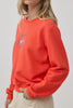 orange crew neck sweatshirt with an embroidered horse design and the message "lucky you."