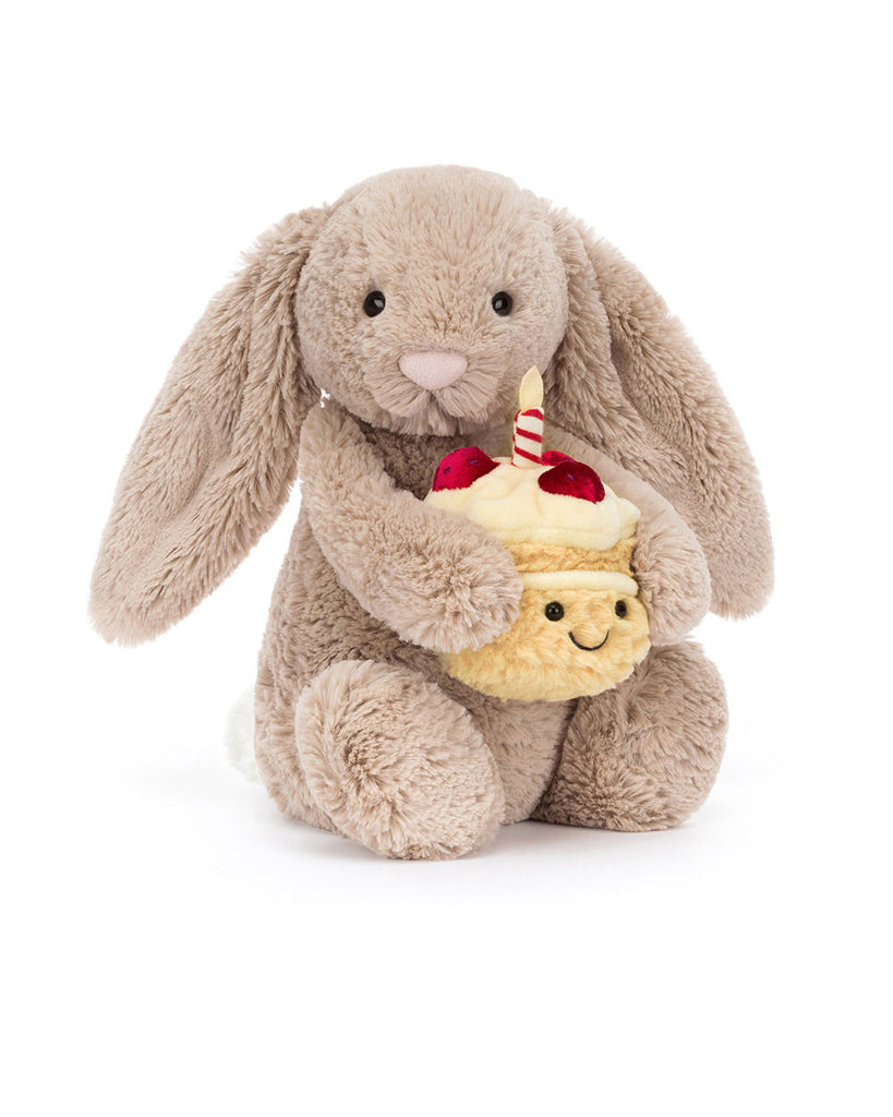 bashful beige birthday bunny, plush beige bunny holding a smiling birthday cake topped with strawberries and a candle