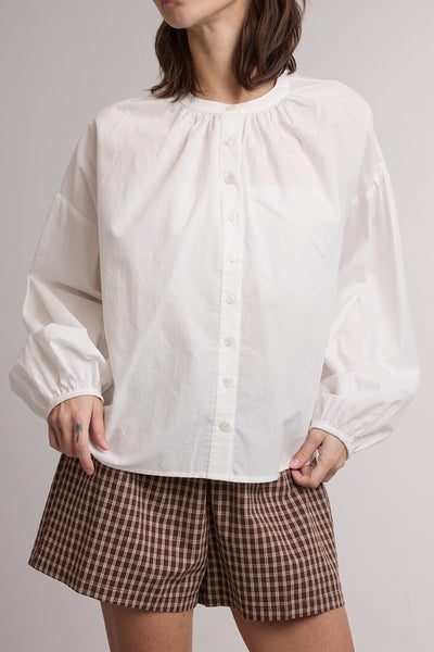 white button down top with a gathered neckline and roomy long sleeves