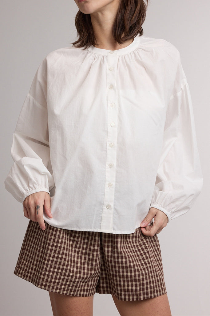 white button down top with a gathered neckline and roomy long sleeves