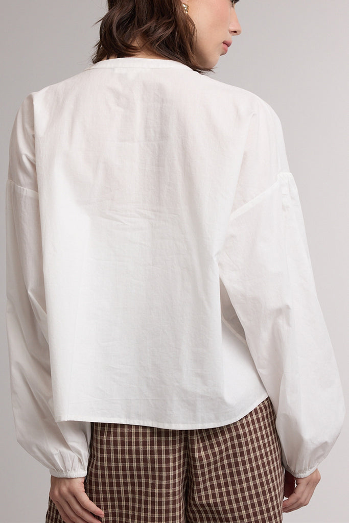 white button down top with a gathered neckline and roomy long sleeves