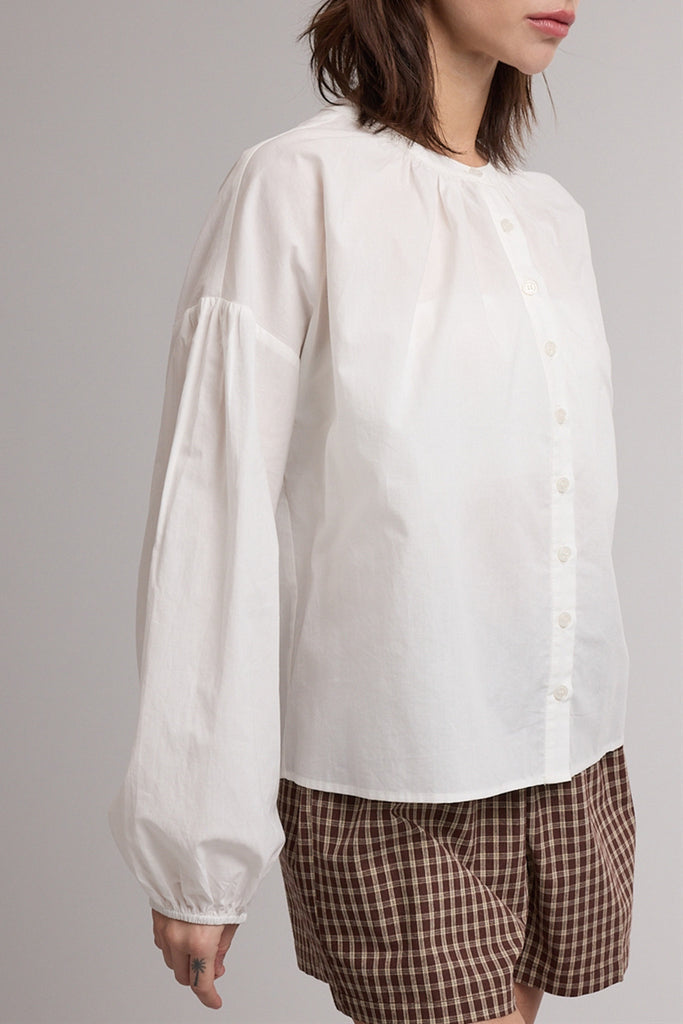 white button down top with a gathered neckline and roomy long sleeves