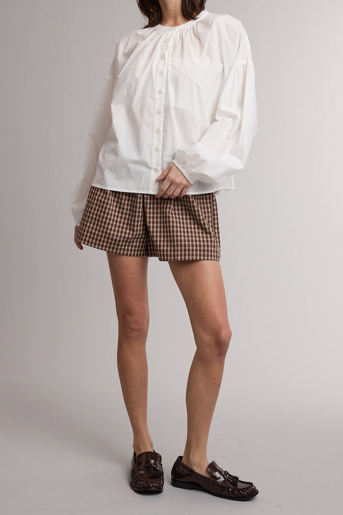 white button down top with a gathered neckline and roomy long sleeves