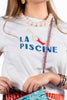 white tee with the message "la piscine" and a cute swimmer graphic