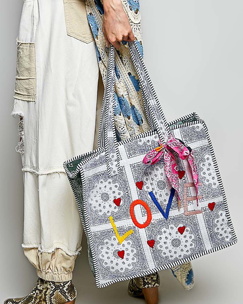 oversized tote bag with a quilted texture and embroidered "love" in bold colors