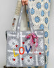 oversized tote bag with a quilted texture and embroidered "love" in bold colors