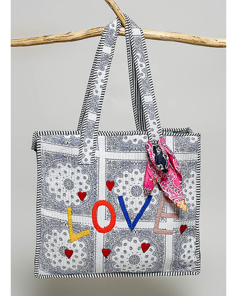 oversized tote bag with a quilted texture and embroidered "love" in bold colors